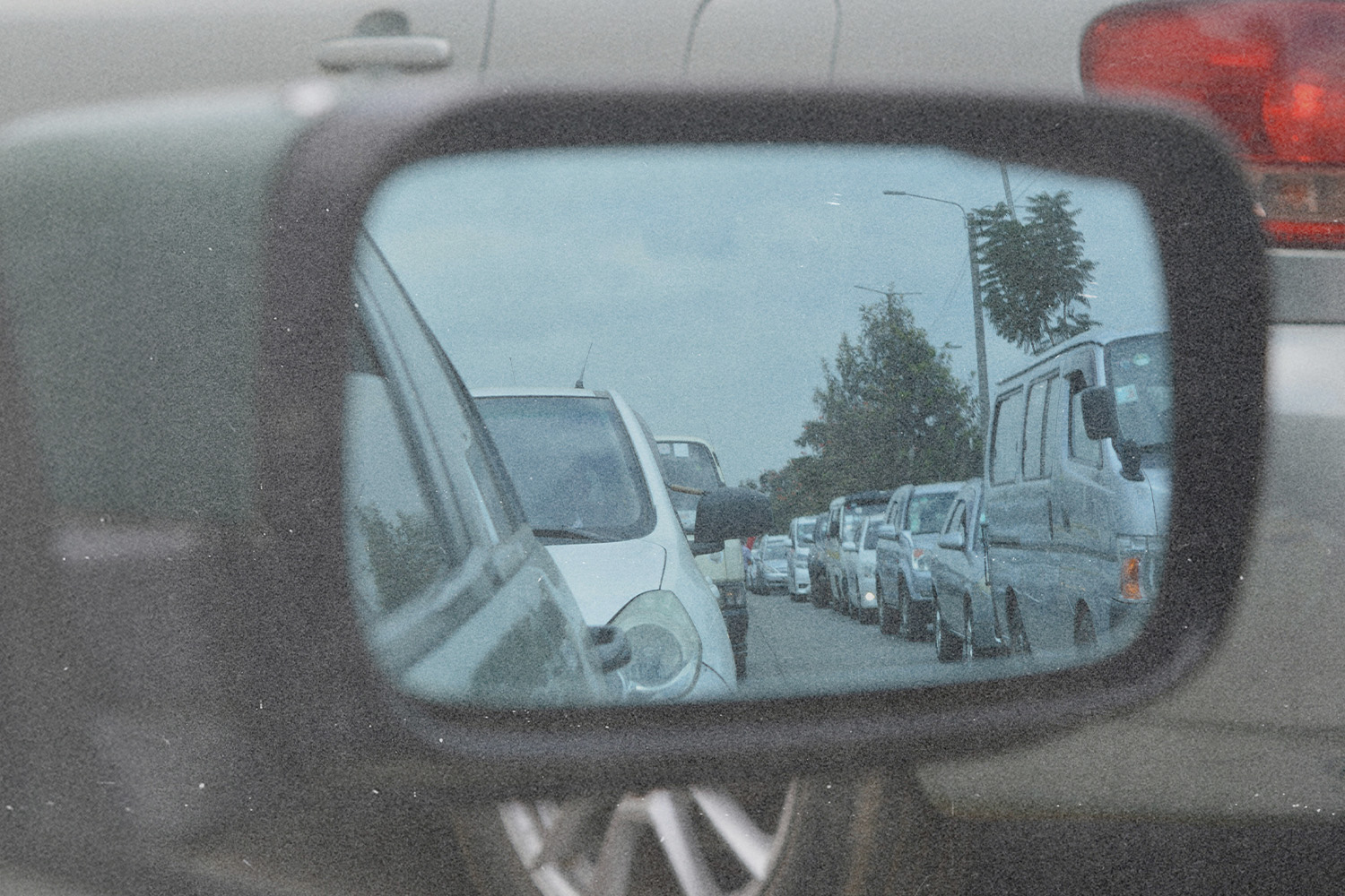 Looking in a rear view car mirror, showing many cars behind